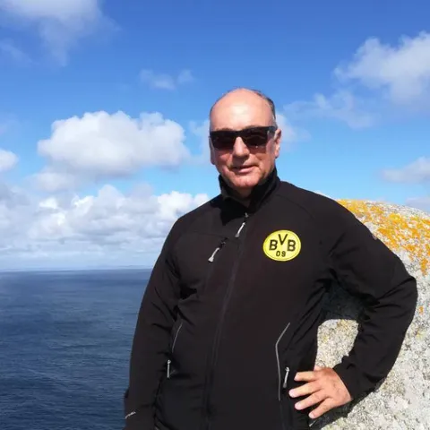 Conny Reuter im BVB-Pullover an einer Steilküste am Meer